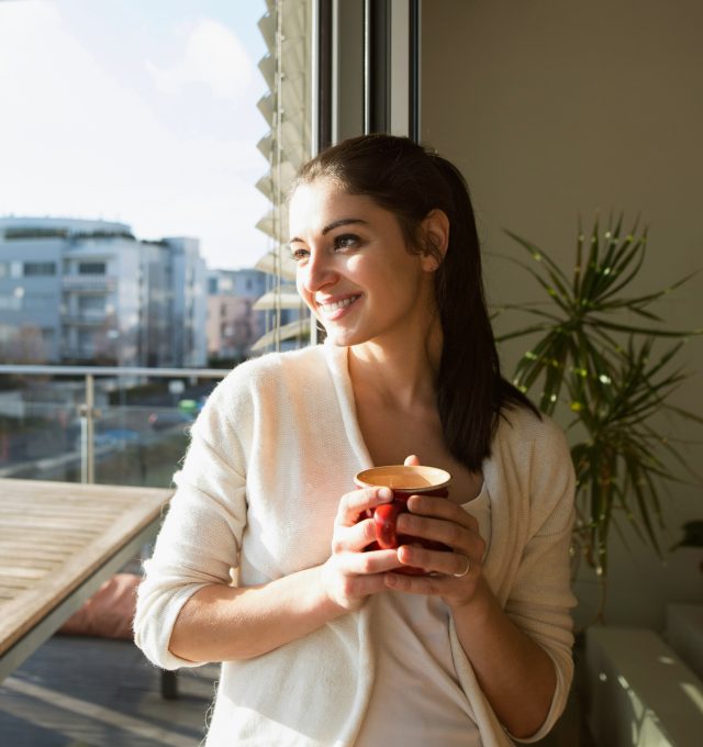 ninth-avenue-capital-about-us-our-company woman smiling looking out a window